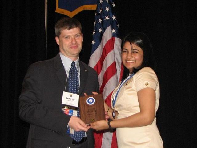 IMG_6553.JPG - Capital District CKI Administrator Jeff Wolff formally retires the 2008-2009 CKI governor. He puts the past governor pin on Avanti Kollaram offering her congratulations on her great year.